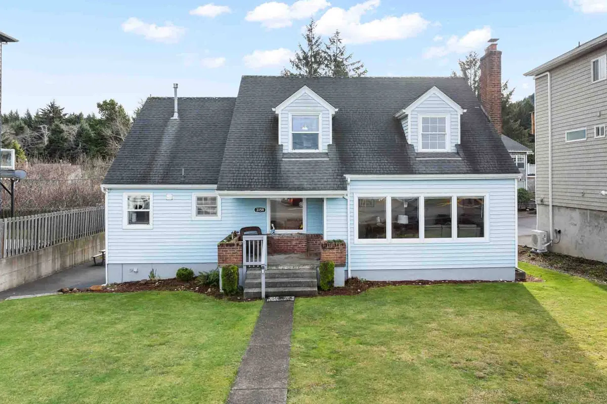 A charming front porch with large windows and a manicured lawn, showcasing ample space for social gatherings. The welcoming symmetry of the house and the inviting porch suggest a place where friends can gather for coffee in the morning or unwind after a day of activities.